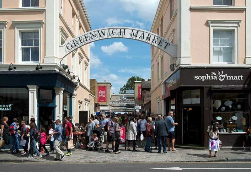 Greenwich market with lots of people coming in and out of entrance.